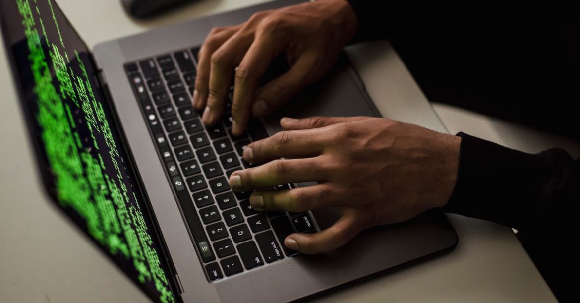 Hands on a keyboard in the dark, representing how to detect a keylogger by inspecting running processes