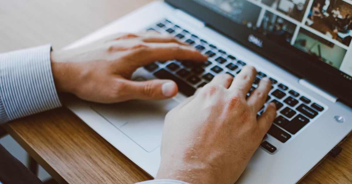 Close-up of hands typing on a laptop keyboard while patching against the PipeWire sandbox escape