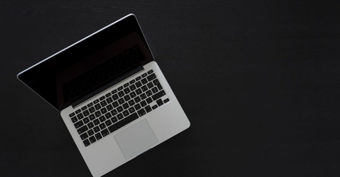 Laptop open on a dark desk, representing a Linux workstation exposed to the PipeWire sandbox escape
